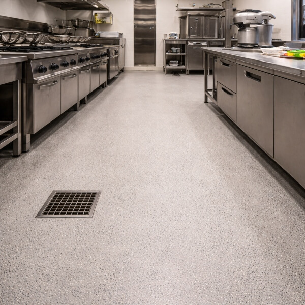 Commercial kitchen epoxy flooring in Perth with a seamless epoxy floor built for safety, drainage and heavy kitchen use.